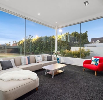 Inside living room of Homely double story unit listing with cream and red furniture